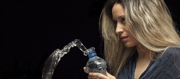 Una mujer con la botella de agua - Sputnik Mundo