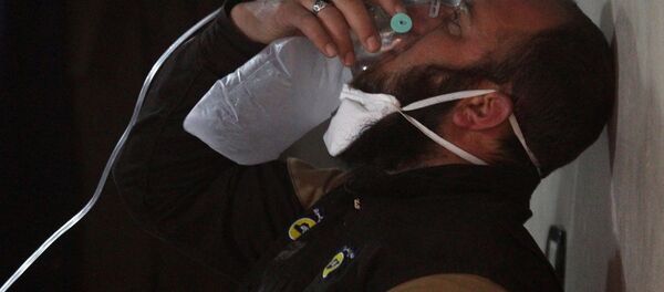 A civil defence member breathes through an oxygen mask, after what rescue workers described as a suspected gas attack in the town of Khan Sheikhoun in rebel-held Idlib, Syria April 4, 2017. - Sputnik Mundo