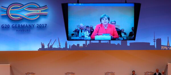 Ángela Merkel, canciller alemana y el logotipo del G20 en Hamburgo - Sputnik Mundo