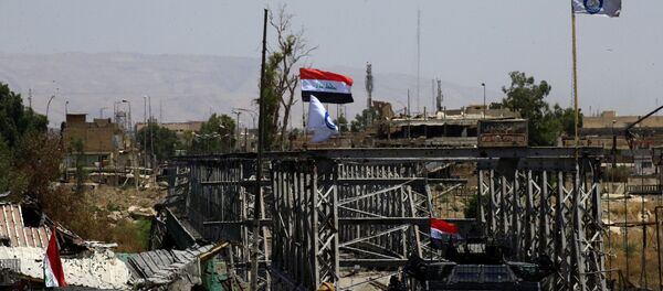 Un vehículo militar y las banderas de Irak cerca del puente destruido en Mosul (archivo) - Sputnik Mundo