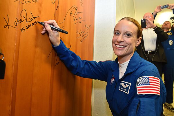 La astronauta estadounidense Kathleen Rubins deja su firma en la puerta del hotel Kosmonavt, justo antes de partir en la Expedición 49 rumbo a la Estación Espacial Internacional. 7 de julio de 2016. - Sputnik Mundo