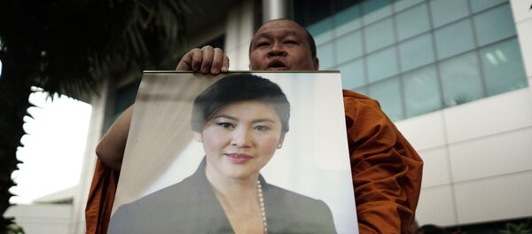 Un monje con la foto de la ex primera ministra de Tailandia, Yingluck Shinawatra - Sputnik Mundo