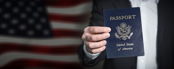 Un hombre sostiene un pasaporte estadounidense - Sputnik Mundo