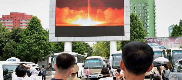 Personas observando el nuevo lanzamiento del misil en un estación de Pyongyang - Sputnik Mundo