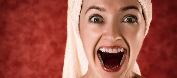 Una mujer con una toalla en la cabeza (imagen referencial) - Sputnik Mundo