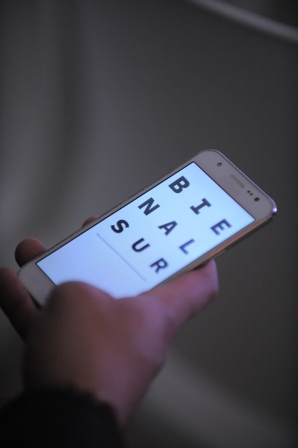 Un móvil con el logo de Bienalsur - Sputnik Mundo