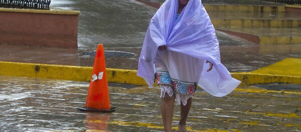 Una mujer se cubre de la lluvia tropical causada por el huracán Franklin - Sputnik Mundo