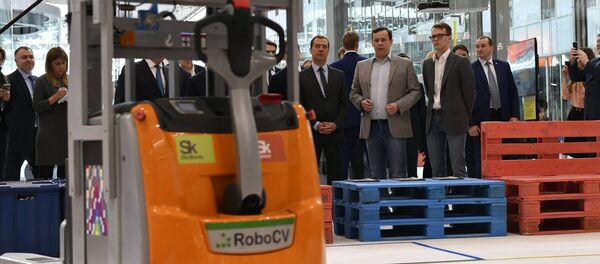 El fundador de RoboCV, Serguéi Máltsev (traje gris), presenta su robot-montacargas al primer ministro ruso, Dmitri Medvedev (a la izquierda de Máltsev) - Sputnik Mundo
