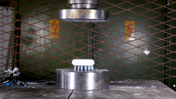 Batería colocada en una prensa hidráulica - Sputnik Mundo