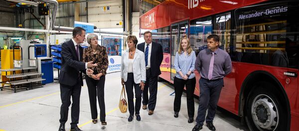 Theresa May, la premera ministra británica cerca del autobús rojo destinado para México - Sputnik Mundo