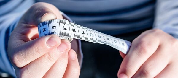 Un centímetro en las manos de un hombre - Sputnik Mundo