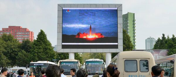 Los nortecoreanos, viendo el lanzamiento del misil balístico, en Pyongyang - Sputnik Mundo