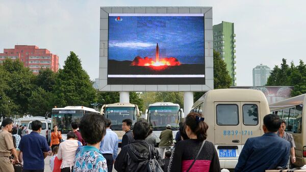 Los nortecoreanos, viendo el lanzamiento del misil balístico, en Pyongyang - Sputnik Mundo