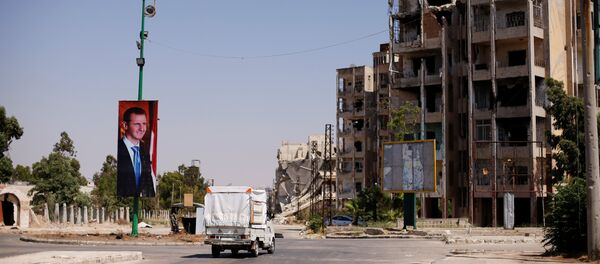 El retrado de Bashar Asad, presidente sirio, en la ciudad de Homs, Siria (archivo) - Sputnik Mundo