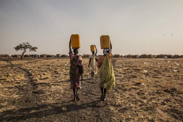 Tres mujeres llevando agua en un campo de desplazados en Melut, Sudán del Sur Tres mujeres llevando agua en un campo de desplazados en Melut, Sudán del Sur - Sputnik Mundo