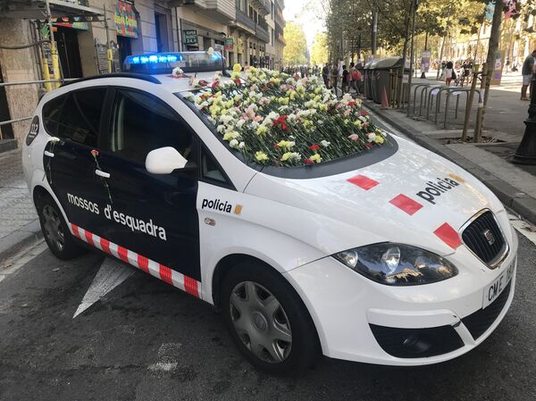 Un vehículo de los Mossos d'Esquadra cortando el acceso a una manifestación a favor del referéndum. La gente decoró el auto con claveles en señal de solidaridad. Un vehículo de los Mossos d'Esquadra cortando el acceso a una manifestación a favor del referéndum. La gente decoró el auto con claveles en señal de solidaridad. - Sputnik Mundo