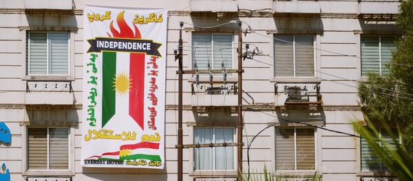 El cartel con la bandera de Kurdistán iraquí - Sputnik Mundo