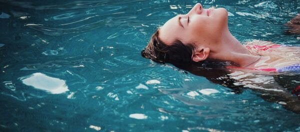 Una joven en una piscina - Sputnik Mundo