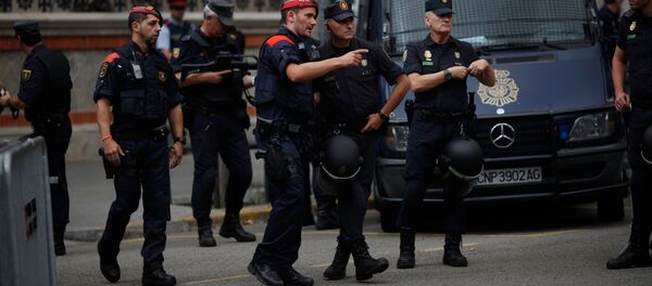 Un agente de Mossos d'Esquadra (policia catalana) habla con su colega de la Policía Nacional española en Barcelona - Sputnik Mundo