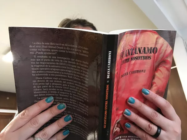 Una persona lee el libro 'Guantánamo entre nosotros', escrito por Diana Cariboni, redactora jefa de la mesa Américas de Sputnik. Una persona lee el libro 'Guantánamo entre nosotros', escrito por Diana Cariboni, redactora jefa de la mesa Américas de Sputnik. - Sputnik Mundo
