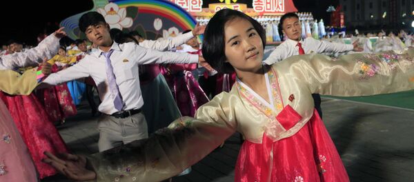 North Korean men and women participate in a mass dance event marking the 20th anniversary of the election of former leader Kim Jong Il as general secretary of the Workers' Party, which is the founding and ruling party of North Korea, at Kim Il Sung Square in Pyongyang, Sunday, Oct. 8, 2017 - Sputnik Mundo