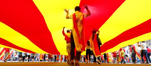 La gente camina debajo de la bandera de Cataluña - Sputnik Mundo