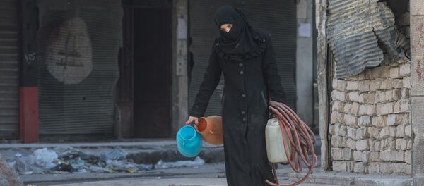 Una mujer camina en una zona residencial de una ciudad siria (imagen referencial) - Sputnik Mundo