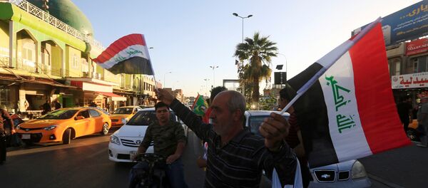 Un hombre vende banderas de Irak en Kirkuk - Sputnik Mundo