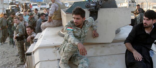 Kurdish Peshmerga fighters sit on a military vehicle north of Kirkuk, Iraq - Sputnik Mundo