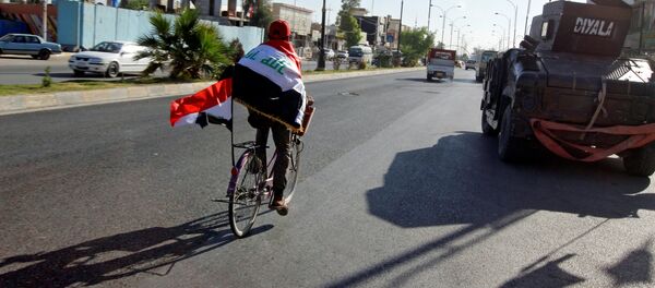 Un hombre con las banderas de Irak en la ciudad de Kirkuk - Sputnik Mundo