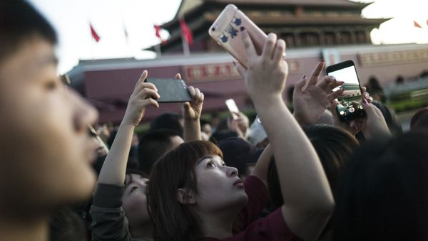 Una joven china sacando una foto con un teléfono móvil en Pekín Una joven china sacando una foto con un teléfono móvil en Pekín - Sputnik Mundo