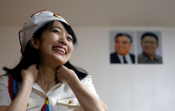 Chunhun, la líder del club de fanes 'Sengun-joshi' ('Chicas militares ante todo'), sonríe frente a los retratos del fundador de la RPDC, Kim Il-sung, y del fallecido líder norcoreano Kim Jong-il. - Sputnik Mundo