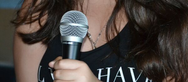 Una mujer con micrófono (imagen referencial) - Sputnik Mundo