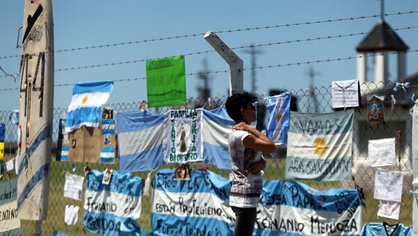 A woman looks at messages and signs in support of the 44 crew members of the missing at sea ARA San Juan submarine - Sputnik Mundo