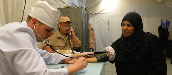 Una residente de Palmira con un médico ruso Una residente de Palmira con un médico ruso - Sputnik Mundo