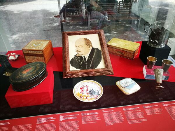 Artesanías de la época soviética en la muestra '100 años de Octubre Rojo', en Montevideo, Uruguay, con un retrato de Lenin bordado en destaque. - Sputnik Mundo