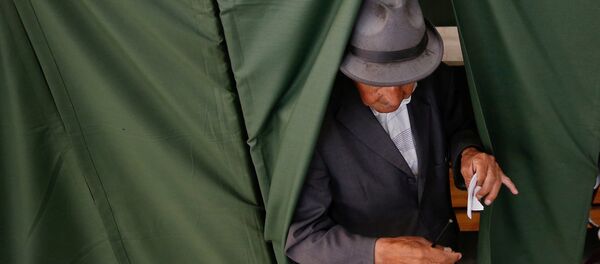 Un hombre votando durante las elecciones presidenciales en Chile - Sputnik Mundo