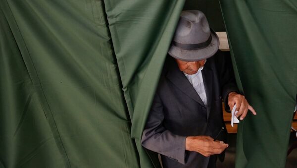 Un hombre votando durante las elecciones presidenciales en Chile - Sputnik Mundo