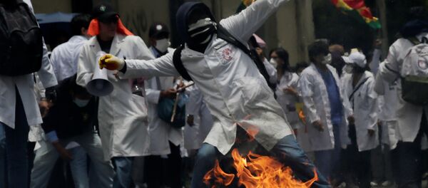 A demonstrator is seen during clashes with riot police as healthcare employees and students refuse new government policies about health system in La Paz, Bolivia - Sputnik Mundo
