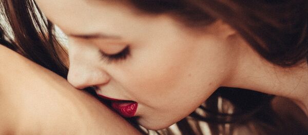 Una mujer besa a un hombre - Sputnik Mundo