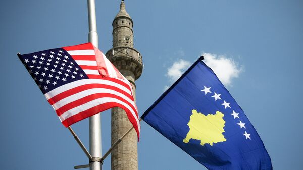 Un minarete entre las banderas estadounidenses y de Kosovo que adornan las calles de la capital, Pristina. - Sputnik Mundo