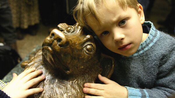 Un niño al lado de la estatua del perro Málchik en el metro de Moscú - Sputnik Mundo