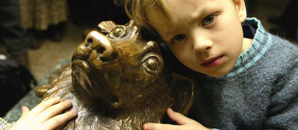 Un niño al lado de la estatua del perro Málchik en el metro de Moscú - Sputnik Mundo