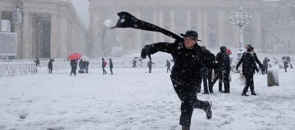 Un cura lanza una bola de nieve en la Plaza de San Pedro, en el Vaticano Un cura lanza una bola de nieve en la Plaza de San Pedro, en el Vaticano - Sputnik Mundo