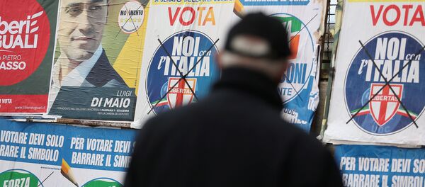 Un hombre mira afiches electorales en Pomigliano D'Arco, en las afueras de Nápoles. - Sputnik Mundo