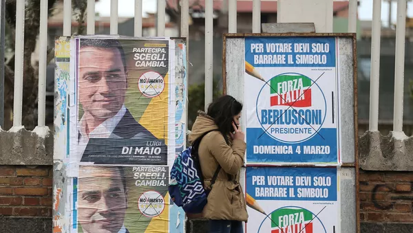 Una mujer camina por delante de afiches electorales en Pomigliano D'Arco, cerca de Nápoles. - Sputnik Mundo