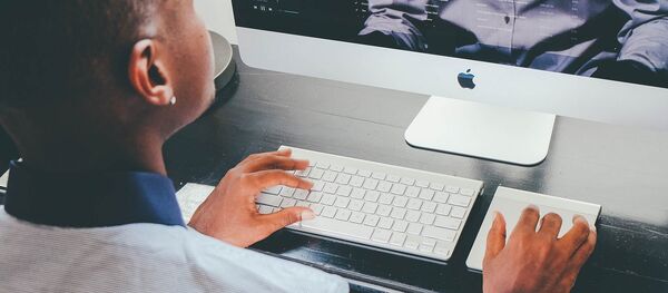 Una mujer usa una computadora - Sputnik Mundo