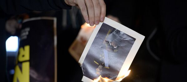 Un manifestante quema una foto del Rey de España, Felipe VI (archivo) - Sputnik Mundo