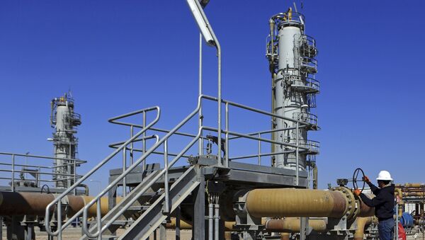 Un trabajador opera válvulas en el campo petrolífero de Qurna Occidental cerca de la ciudad de Basra, Irak - Sputnik Mundo