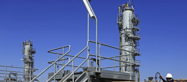 Un trabajador opera válvulas en el campo petrolífero de Qurna Occidental cerca de la ciudad de Basra, Irak - Sputnik Mundo